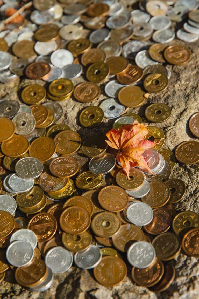 collection of different coins on rocky surface